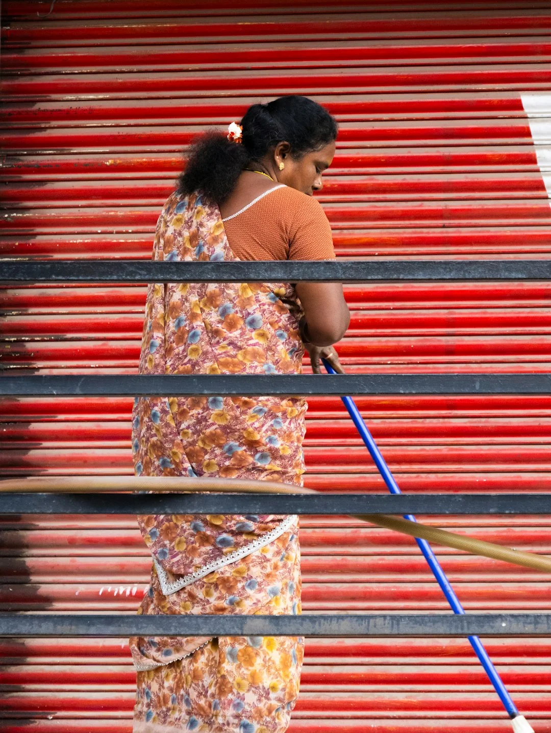 Un travailleur nettoie les vitres d'un gratte-ciel, harnaché, dans un environnement urbain.